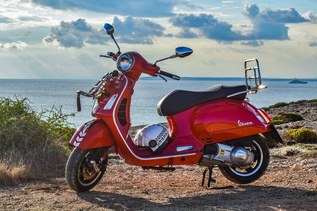 Scooter Vespa rouge au bord de la mer